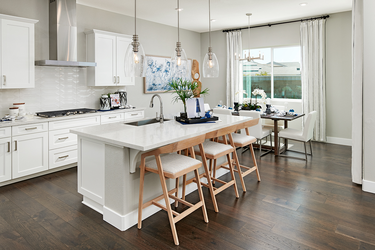 Elegant kitchen with white cabinetry, a center island and an adjacent dining nook