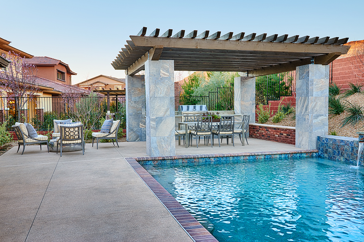 Beautiful backyard with a pool, pergola, sitting areas and a grill
