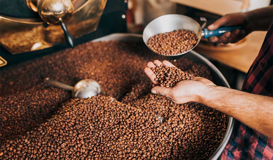 A large container of freshly roasted coffee beans, perfect for host gifts