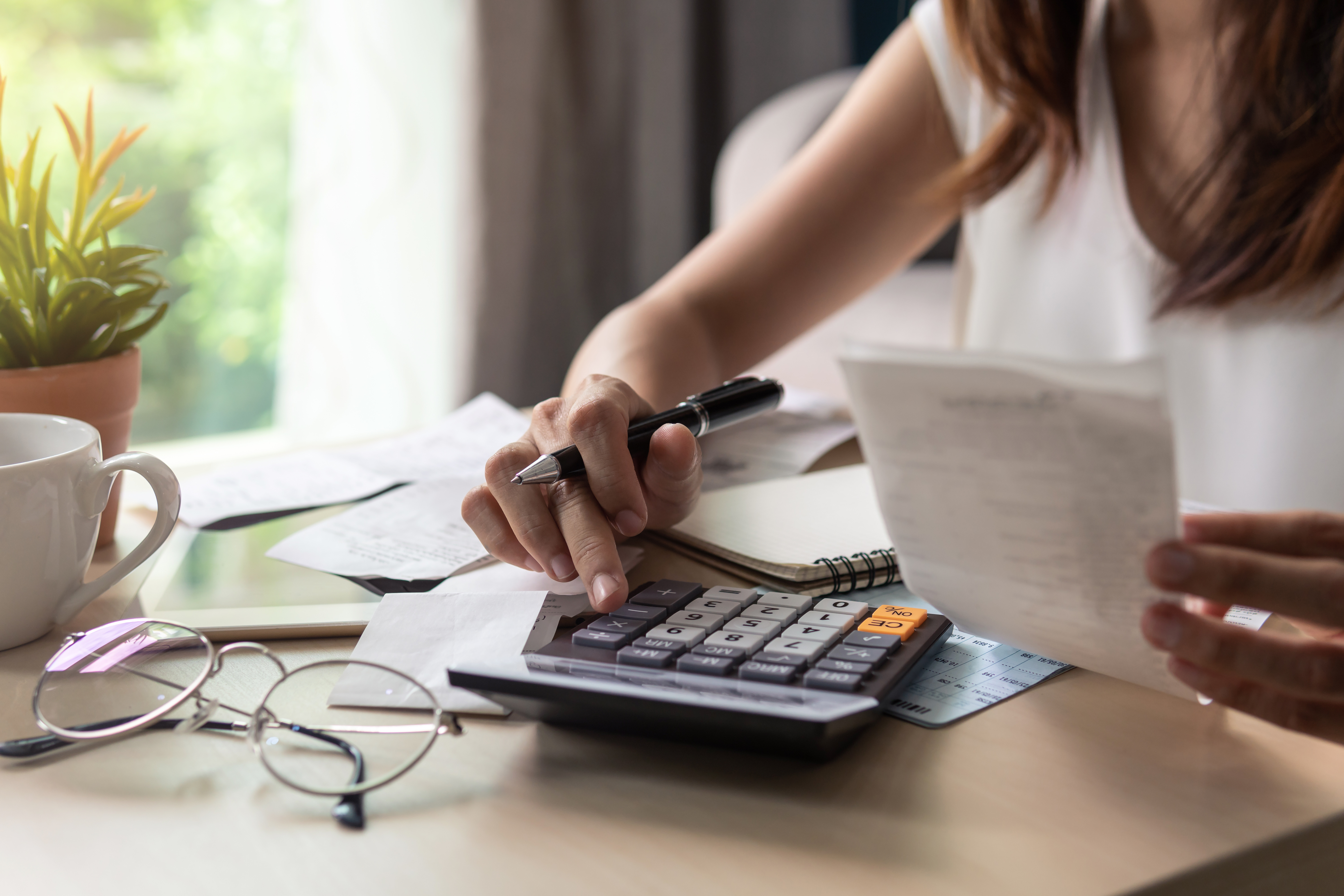 Woman crafting a budget on a calculator