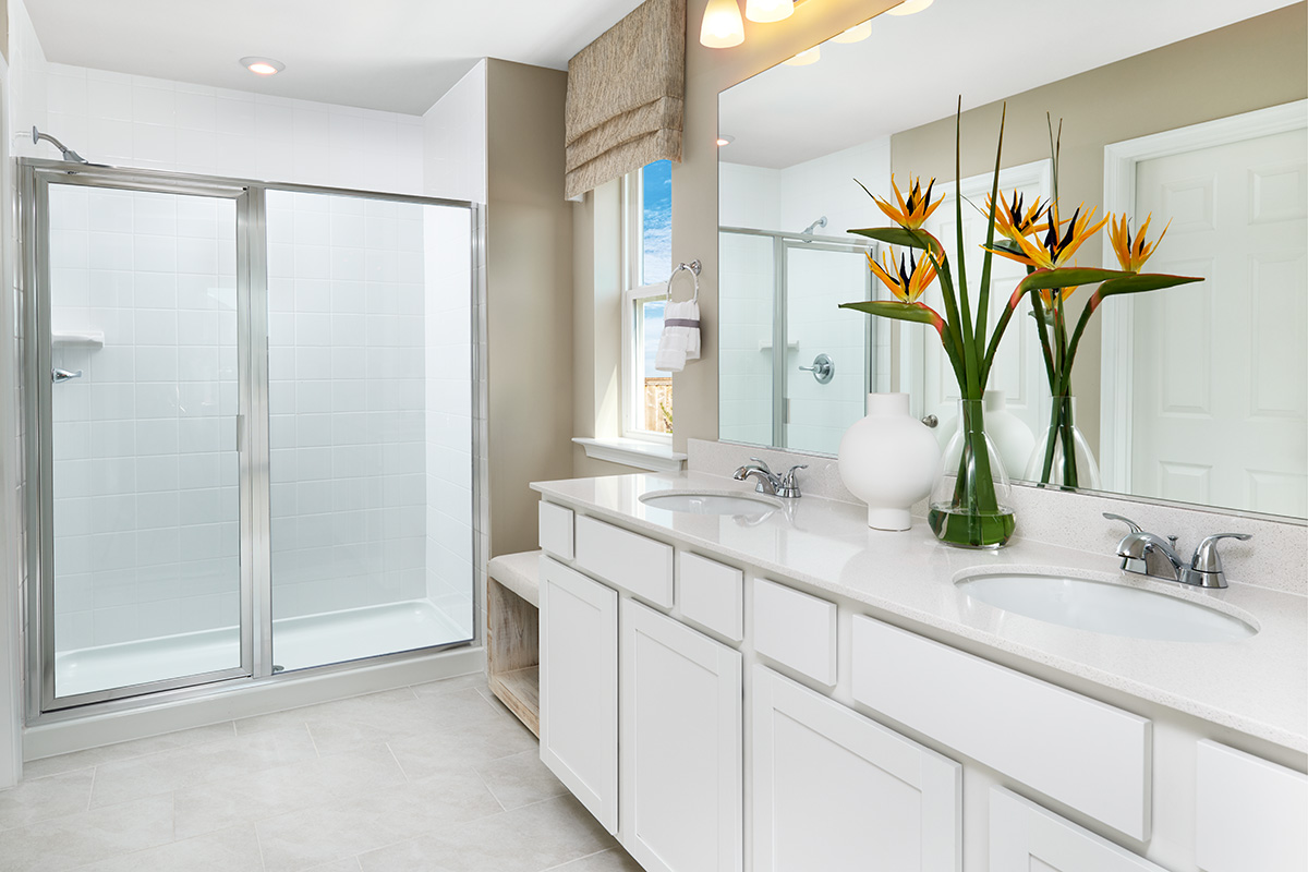 Clean bathroom with walk-in shower and double sinks. 