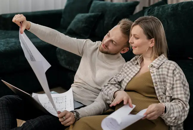 Couple sitting on the couch reviewing blueprints