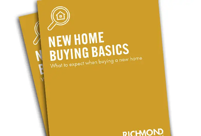 Stack of New Home Buying Basics guides with picture of a kitchen on the cover and Richmond American Homes logo